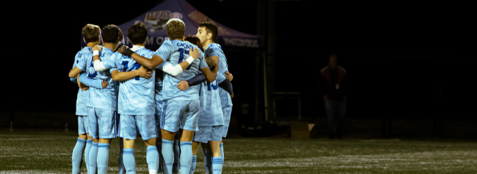 Men's Soccer team huddles in 2022 season.