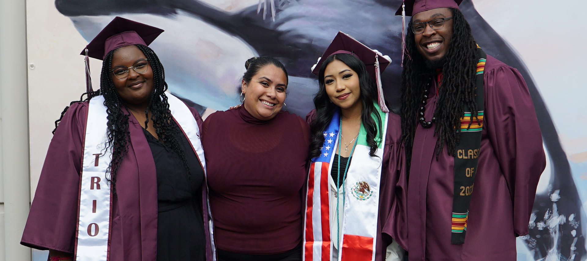 Four WCC graduates stand and pose in their caps and gowns.