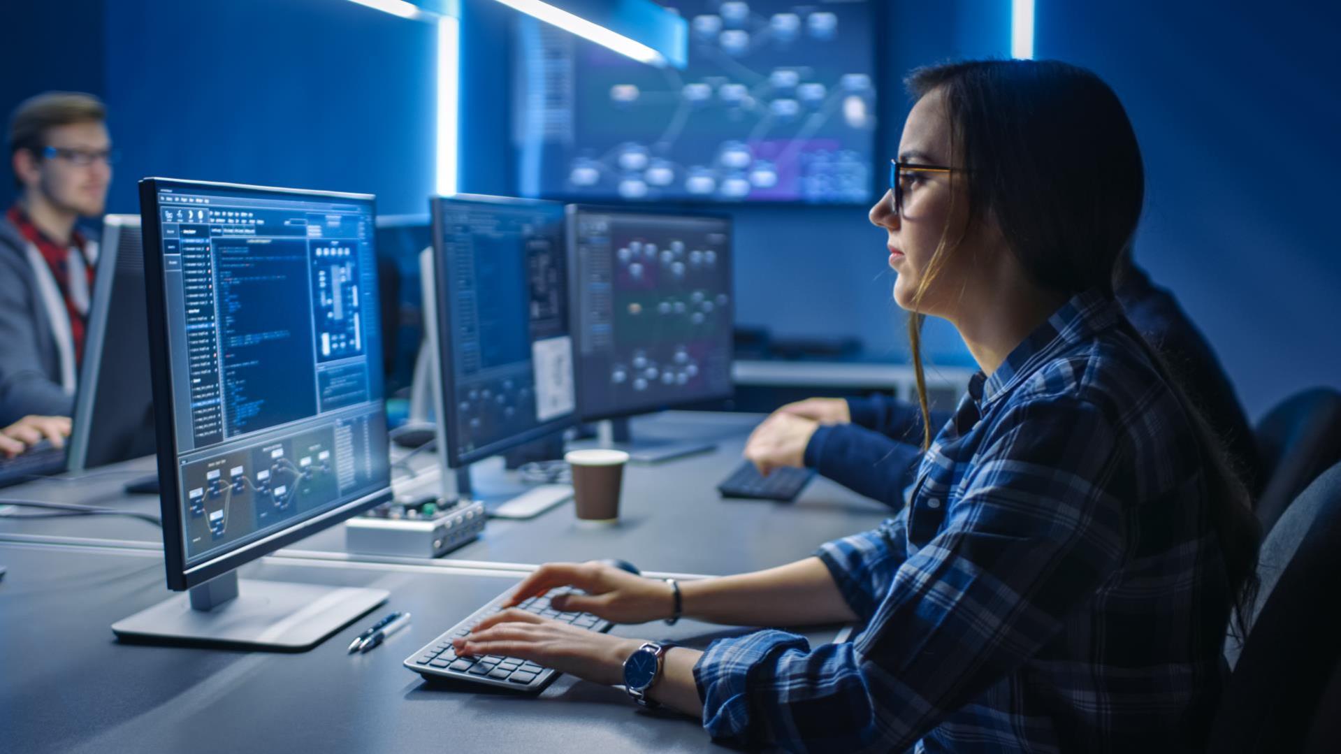 A female sitting in a computer lab writing code