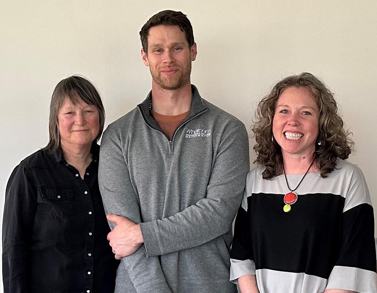 Three staff members stand next to one another celebrating attainingtenure