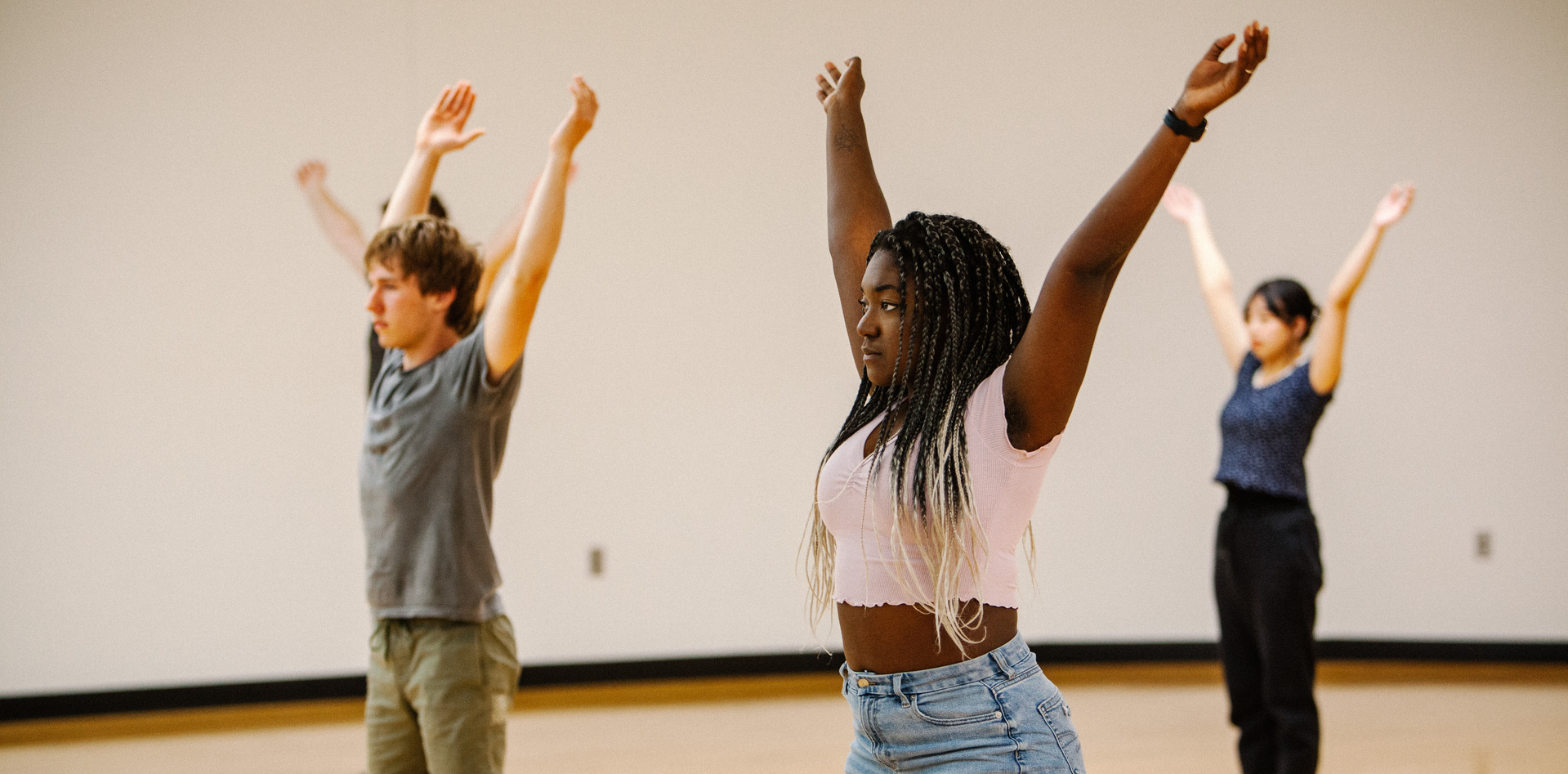 students dancing with their arms up