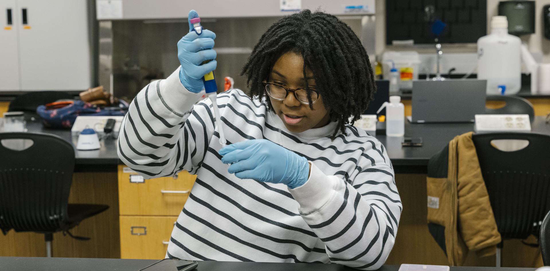 A WCC student in a chem lab using a dropper