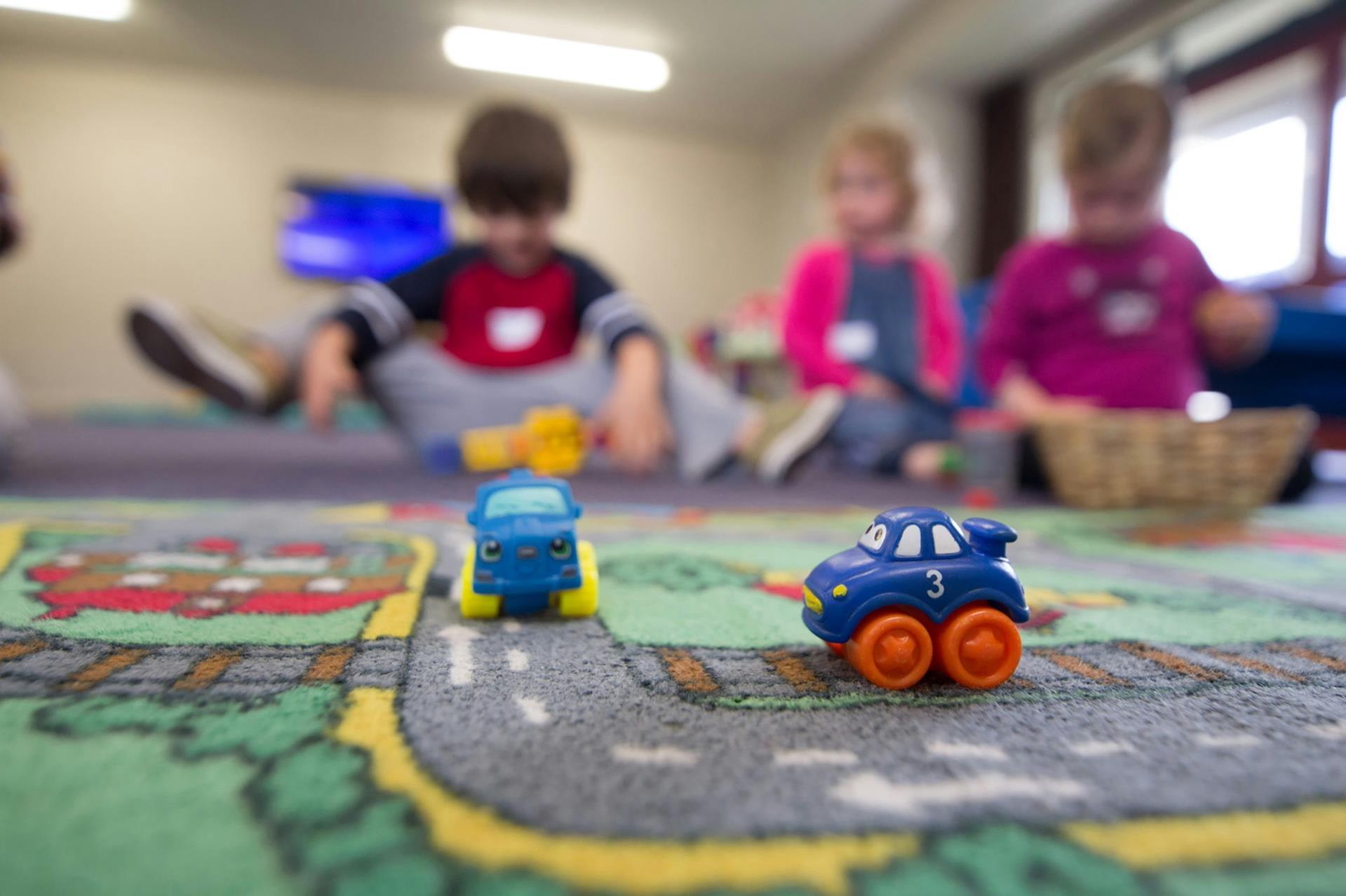 Close-up image of children playing with toy trains