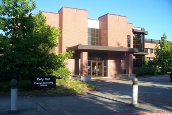 Kelly Hall exterior with building sign and trees