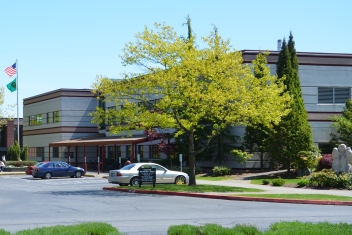 Laidlaw Center exterior with trees and cars parked in front